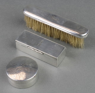 Three silver toilet items comprising a rectangular box, circular ditto and a clothes brush, London 1910, 11 and 13, 