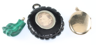A Victorian carved malachite fist pendant, a jet locket and a gilt locket 