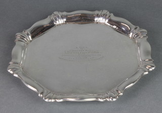 A silver salver with fancy rim and presentation inscription on ball feet, Birmingham 1928 11", 548 grams