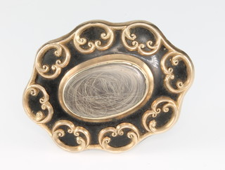 A 19th Century gilt and enamelled mourning brooch with hair locket and scroll mount, dated 1857