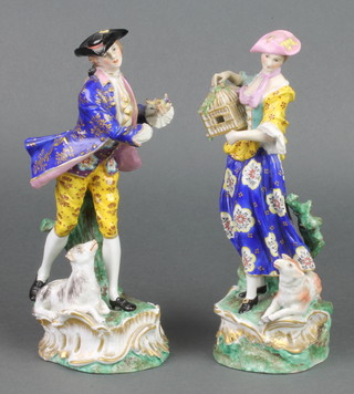 A pair of Derby figures of a lady and gentleman, the gentleman with a dog at his feet, the lady carrying a cage with a sheep at her feet 9" 
