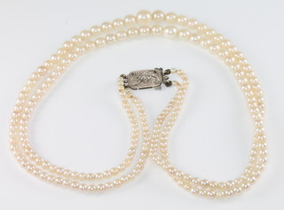 A double strand of graduated cultured pearls with a 9ct white gold diamond set clasp  