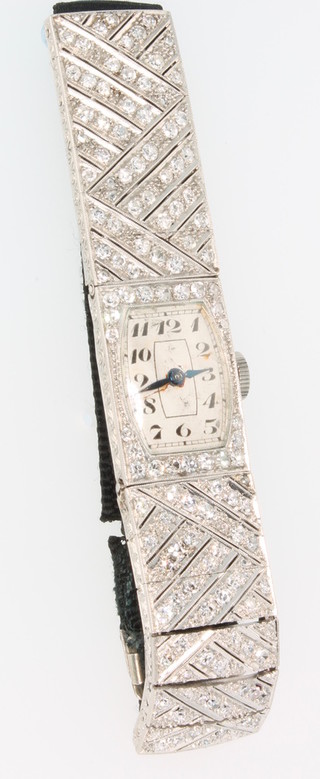 A lady's Art Deco platinum and diamond cocktail wristwatch set 122 diamonds with tonneau shaped dial and silk trap 
