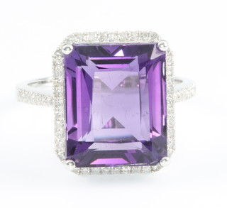 A 14ct white gold emerald cut amethyst ring, the centre stone approx 8ct surrounded by briliant cut diamonds approx. 0.31ct, size M 1/2