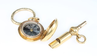 An 18ct yellow gold whistle watch key together with a gilt compass on a gilt ring 