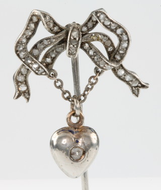 A diamond set ribbon pin with diamond set heart drop 