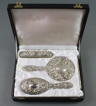 A cased 4 piece repousse silver brush set with masks, birds and scrolls Birmingham 1983