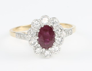 An 18ct yellow gold oval ruby and diamond ring the centre stone 0.6ct surrounded by 10 brilliant cut diamonds approx. 0.5ct, size O