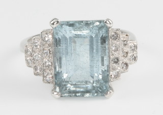 An 18ct white gold aquamarine and diamond cocktail ring, the emerald cut centre stone approx. 5.80ct  flanked by 3 tiers of 9 diamonds approx. 0.50ct, size N 1/2