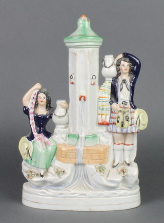 A Victorian Staffordshire figure of a lady and gentleman water carrier standing beside a fountain 12 1/2" 