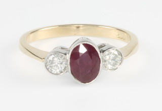An 18ct yellow gold ruby and diamond ring, the oval ruby flanked by brilliant cut diamonds, size O