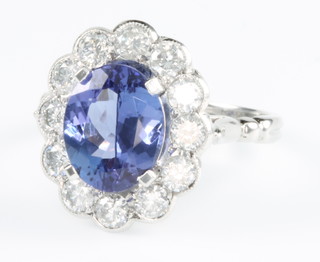 An 18ct white gold oval tanzanite and diamond ring, the oval stone approx. 2.65ct surrounded by 12 brilliant cut diamonds approx. 1ct, size M 