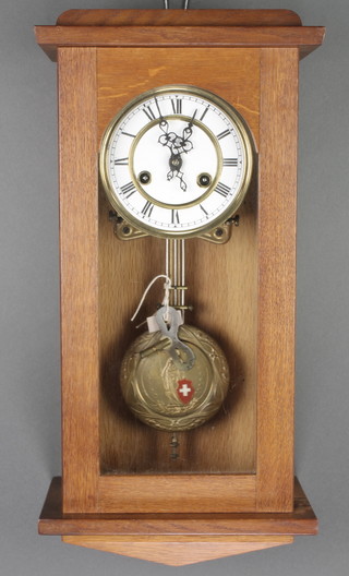 A striking Vienna style regulator with 5 1/2" enamelled dial and Roman numerals, striking on a gong, the pendulum embossed a standing figure of a lady with a Swiss shield and contained in an oak case 