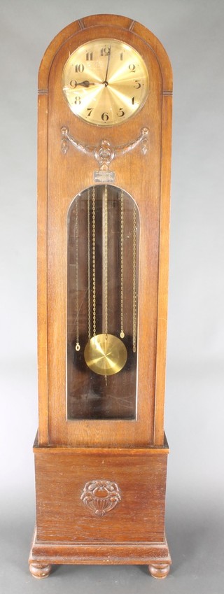 A 1930's chiming longcase clock with 11" circular gilt dial and Arabic numerals contained in an oak arch shaped case, raised on bun feet 81 1/2"h 