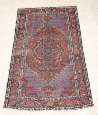 A Persian Bakhtiari rug with red and blue ground and central medallion 94" x 58"  