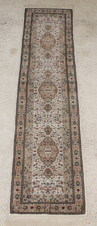 An Indo Persian white and blue ground floral patterned runner with 3 medallions to the centre 121" x 31" 