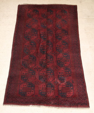 An Afghan blue and red ground rug with 21 octagons to the centre 129" x 72" 
