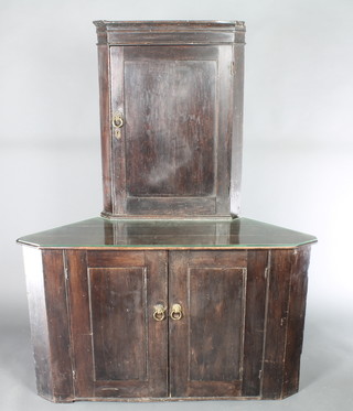 A 19th Century pine double corner cabinet, the upper section with moulded cornice and cupboard enclosed by panelled door, the base enclosed by a pair of panelled doors with lion mask handles 61"h x 47 1/2"w x 27 1/2"d 