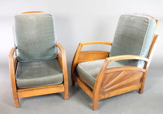 A pair of Art Deco oak show frame reclining arm chairs with sunburst panels to the side and with cushions upholstered in blue Dralon 