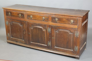 An 18th Century oak dresser base fitted 3 long drawers above a triple cupboard enclosed by panelled doors 35"h x 73"w x 21"d 