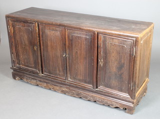 A Chinese hardwood sideboard enclosed by 4 panelled doors raised on a carved base 30"h x 58"w x 17"d 