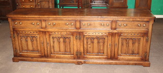 A carved oak 17th Century style oak dresser base, the top formed of 3 planks, fitted 4 long drawers above a pair of double cupboards with arcaded panelled decoration with H framed hinges, raised on bracket feet 33"h x 90"w  x 21"d
 