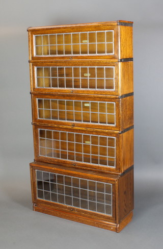 An oak 5 tier Globe Wernicke bookcase enclosed by lead light effect panelled doors, 64"h x 34"w  the base x 13"d, the other sections x 10"d 