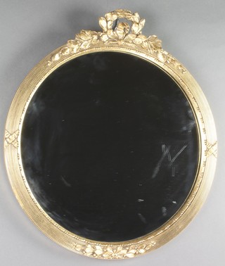 A circular plate wall mirror contained in a gilt reeded frame surmounted by a garland of laurel, 12"