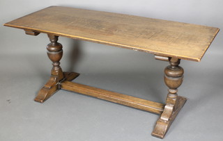 An oak rectangular refectory style dining table, raised on cup and cover supports with H framed stretcher 30"h x 26 1/2"w x 66"l 
