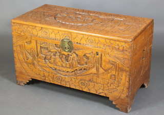 A Chinese heavily carved camphor coffer with hinged lid and brass drop handles, raised on bracket feet 23"h x 39"w x 20" 
