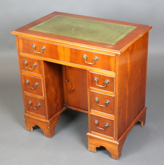 A Georgian style yew kneehole pedestal desk/dressing table with inset green leather writing surface, fitted a cupboard enclosed by panelled doors above 1 long and 6 short drawers, raised on bracket feet 29 1/2"h x 30"w x 19 1/2"d 