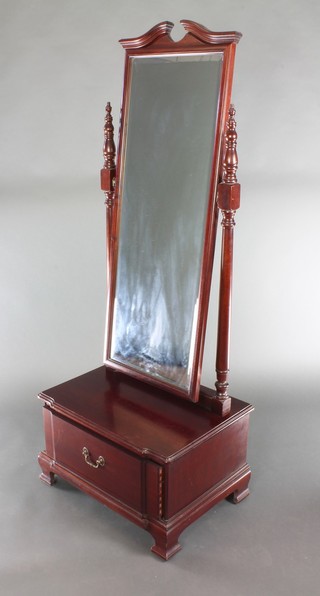 An arched rectangular bevelled plate cheval mirror contained in a mahogany frame, the base fitted a drawer on ogee bracket feet 64 1/2"h x 25"w, the base 19"d 