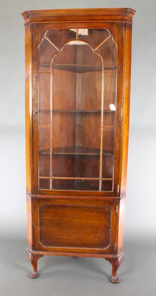 An Edwardian mahogany double corner cabinet with moulded cornice, fitted shelves enclosed by astragal glazed panelled door the base enclosed by a panelled door, on cabriole supports 72"h x 28"w x 16"d 