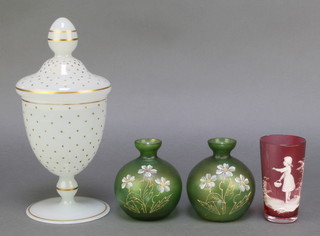 A Mary Gregory style cranberry beaker decorated with a figure of a girl 4 1/", 2 Continental green squat vases decorated with flowers 3" and a gilt decorated jar and cover 10" 