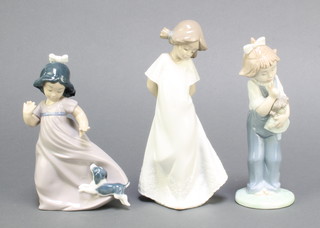 Three Nao figures a girl with puppy 6 1/2", a girl with doll 7 1/2" and a girl in a long dress 8" 