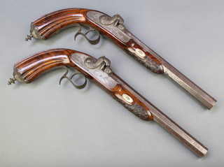 A pair of 19th Century percussion pistols with octagonal barrels marked 1 and 2, with carved walnut grips inscribed J A Petry decorated with hunting dogs and birds 8 1/2"