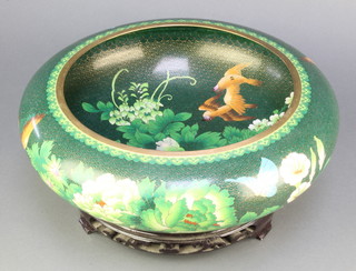 A Japanese green ground and floral patterned cloisonne enamelled bowl decorated birds amidst branches 7" h x 15" diam. on a pierced hardwood stand 