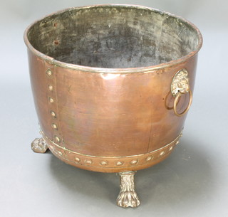 A 19th Century circular copper copper converted for use as a log basket with brass ring handles and paw feet 20"h x 23" diam. 
