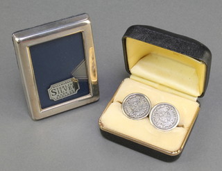 A pair of silver coin effect cufflinks and a miniature photograph frame