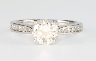 An 18ct white gold diamond ring approx 1.2ct with 11 brilliant cut channel set diamonds to each shoulder, size L 1/2
