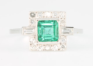An 18ct yellow gold Art Deco style emerald and diamond ring, the centre square cut stone surrounded by brilliant cut and baguette cut diamonds, size O 
