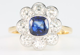 An 18ct yellow gold sapphire and diamond ring, the cushion cut sapphire surrounded by 8 brilliant cut diamonds, the centre stone approx. 1.2ct, diamonds 1.2ct, size R 