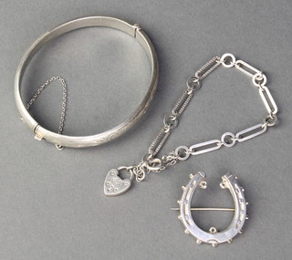 A Victorian silver horse shoe brooch, a charm bracelet and a hollow bracelet