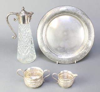 A silver plated mounted ewer with mask spout, a repousse cream jug and sugar bowl and a pewter hammer patterned tray