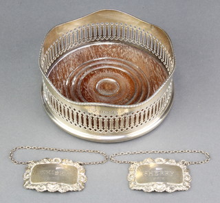 A silver coaster with pierced decoration and wavy rim, London 1985 5 1/2" and 2 repousse silver spirit labels Sherry and Whisky 