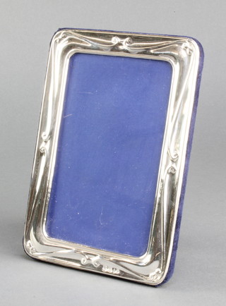 A rounded rectangular repousse silver photograph frame 6 1/2" x 4 1/2" 