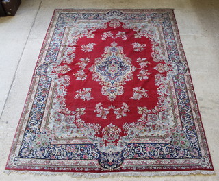 A Kirman red and blue carpet with central medallion 141" x 105", in wear 
