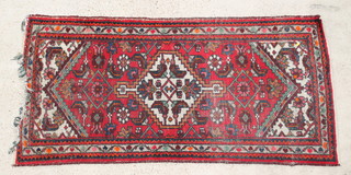A Caucasian style rug with diamond medallion to the centre within multi row borders 77" x 37"