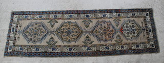 A white and blue ground Caucasian style runner with 4 octagons to the centre, signed, 133" x 43" 