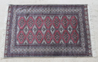 A red and white ground Bokhara carpet with 6 diamonds to the centre flanked by 14 stylised octagons 75" x 49" 